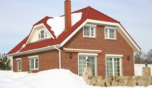 Залежи снега с крыши нужно счищать, чтобы снять нагрузку и ликвидировать потенциальный очаг сырости